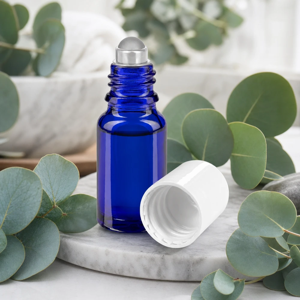 Frasco de farmácia azul 10ml tampa roll-on branca Frasco roll-on de vidro de farmácia azul cobalto, com 10 ml, com esfera de aço inoxidável e tampa branca sobre fundo de mármore