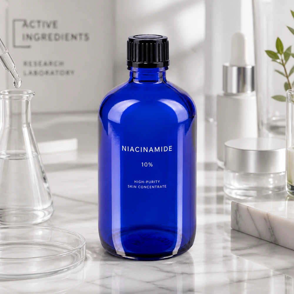 Frasco de farmácia azul 100ml com tampa de conta-gotas 1mm preto standard Frasco de farmácia azul cobalto de 100 ml com etiqueta de niacinamida sobre uma superfície de mármore num ambiente de laboratório