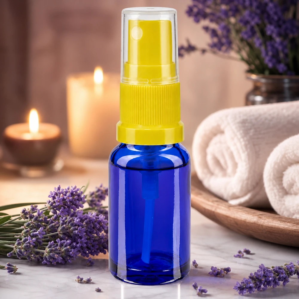 Acessório de aromaterapia: frasco pulverizador azul de 30 ml com bico pulverizador amarelo ao lado de flores de lavanda
