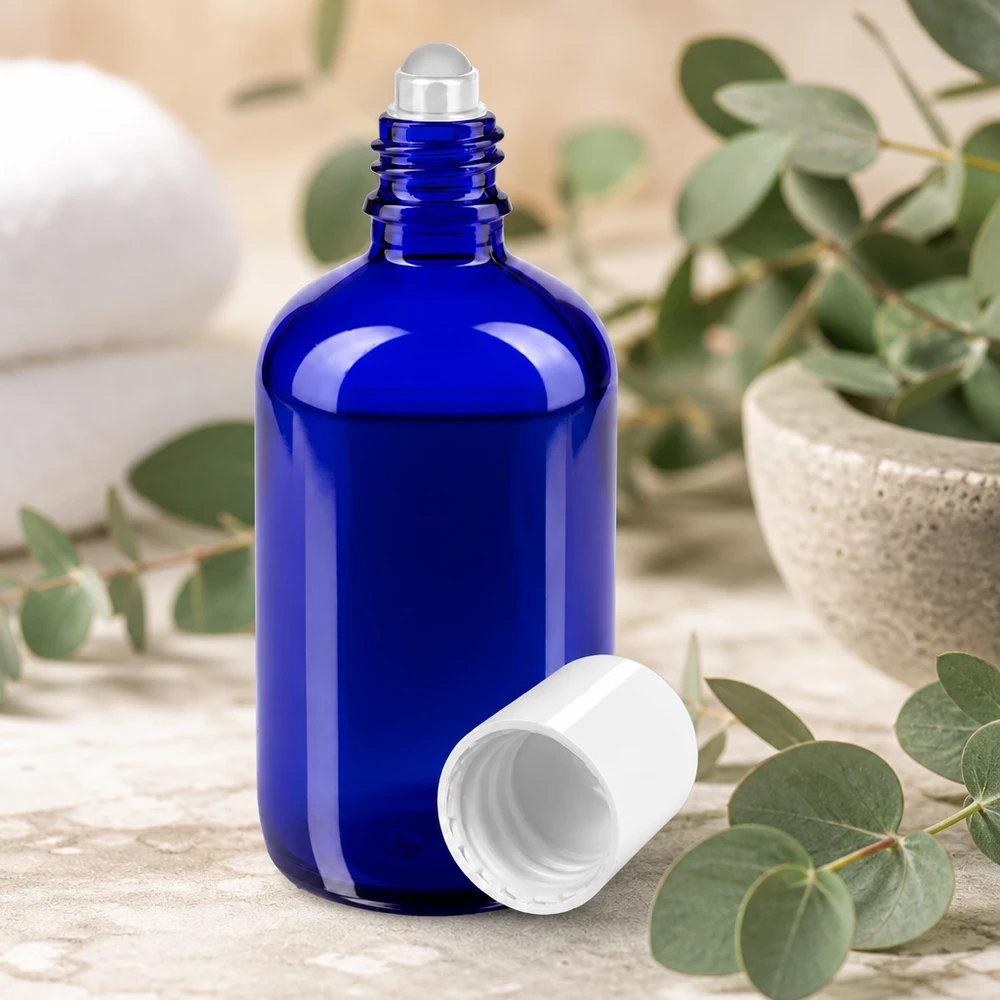 Frasco de farmácia azul 100ml tampa roll-on branca Frasco roll-on de 100 ml em azul, com esfera de aço e tampa branca, entre ramos de eucalipto