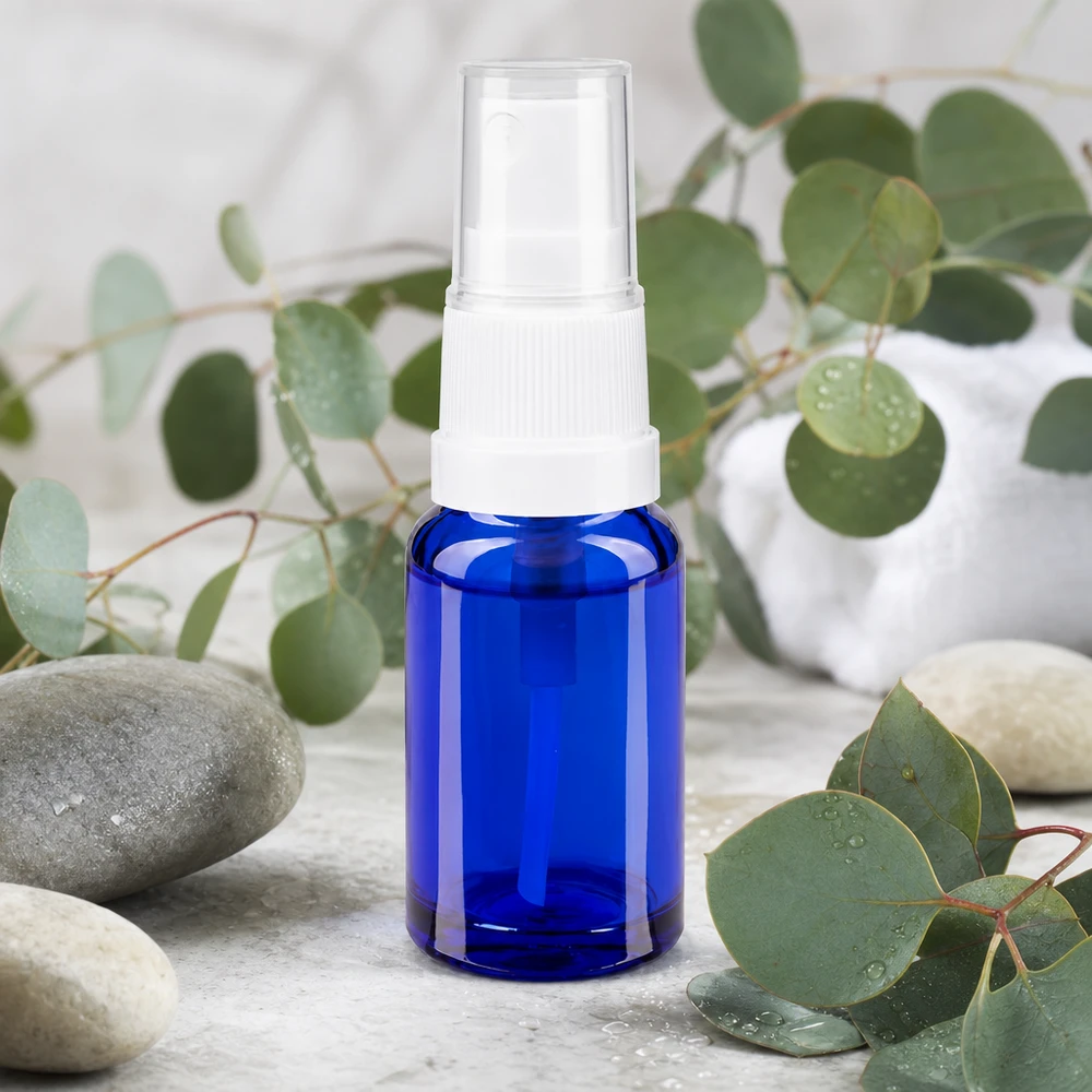 Frasco de farmácia azul 10ml spray top branco Frasco de 10 ml em vidro farmacêutico azul cobalto com um pulverizador branco rodeado por ramos de eucalipto