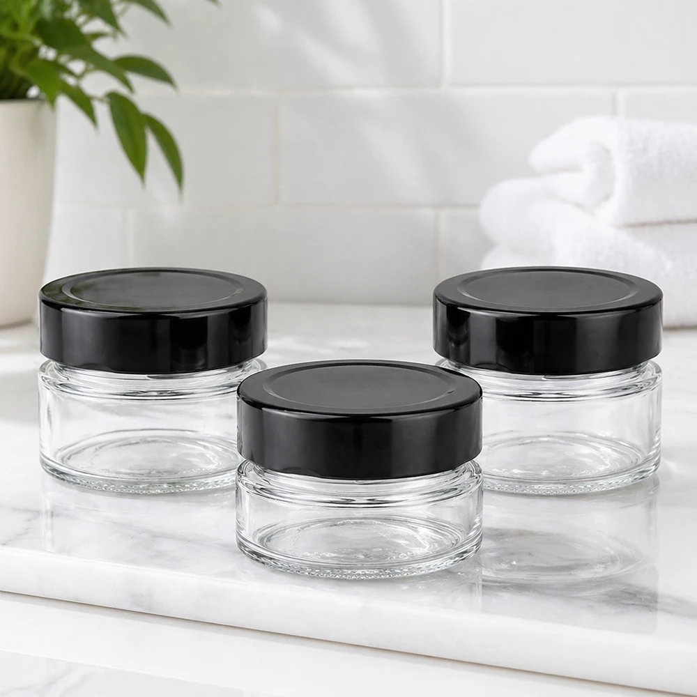 Frasco redondo de 80 ml + tampa BasicSeal preta profunda UNiTWIST Três frascos redondos de 80 ml com tampas BasicSeal pretas UNiTWIST sobre tampo de mármore branco Ambiente de casa de banho vazio