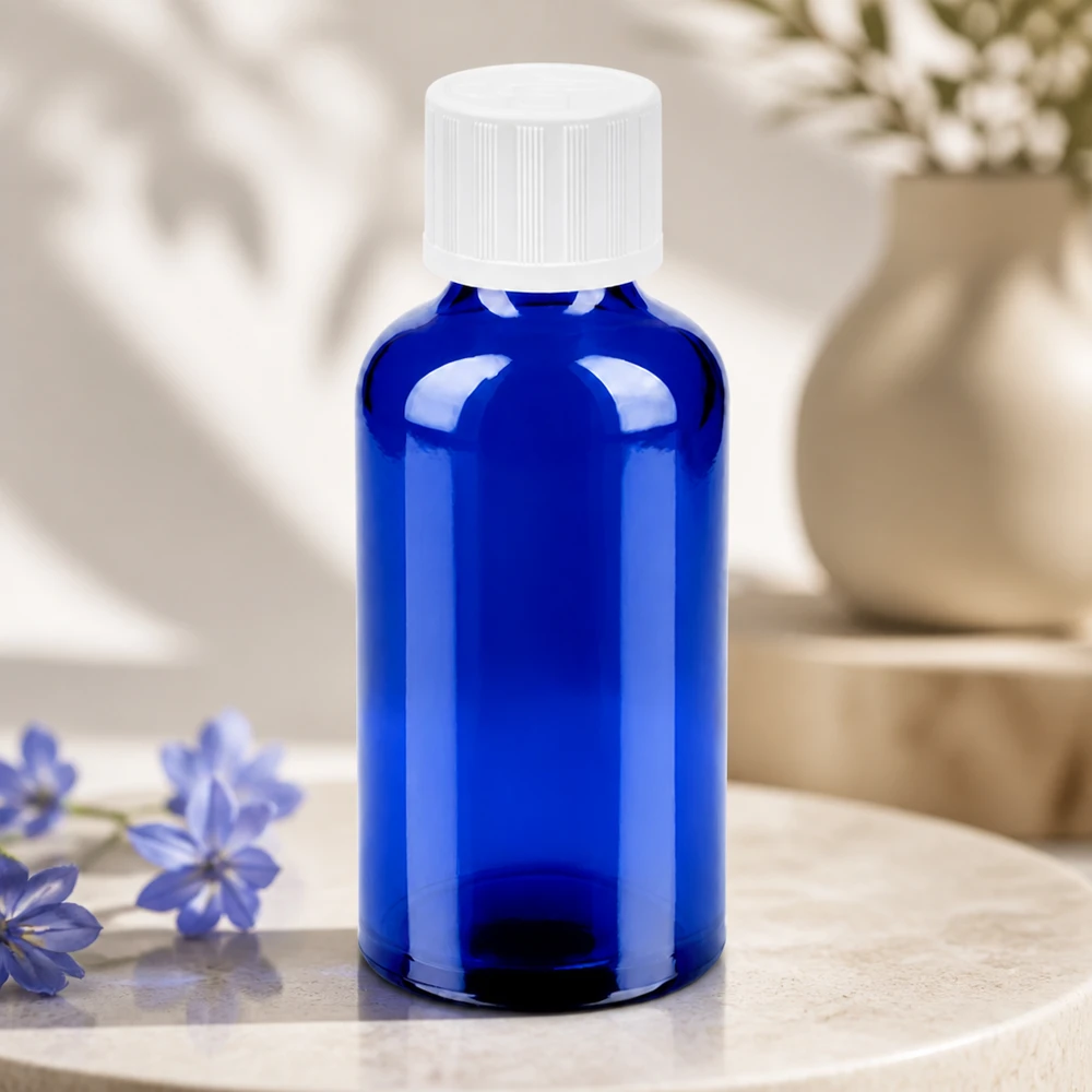 Frasco de vidro compacto de 50 ml em azul brilhante com tampa branca para uma dosagem precisa