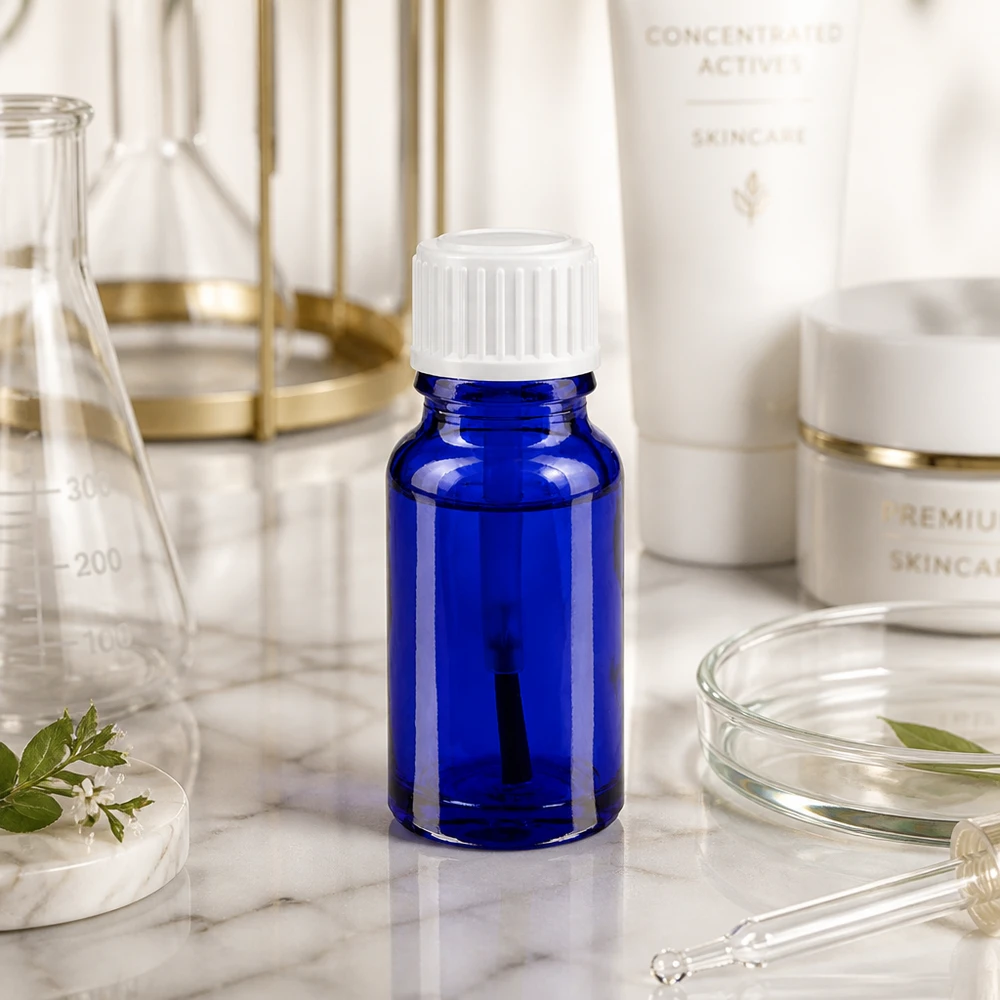 Pequeno frasco de vidro azul de 10 ml com tampa de rosca branca sobre mármore, entre material de laboratório