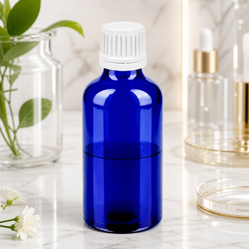 Frasco redondo de vidro de 50 ml em azul brilhante com uma prática tampa branca com conta-gotas
