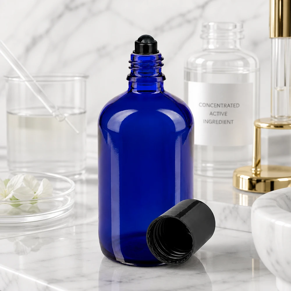 Frasco roll-on aberto de 100 ml em azul cobalto com aplicador esférico preto num ambiente de laboratório