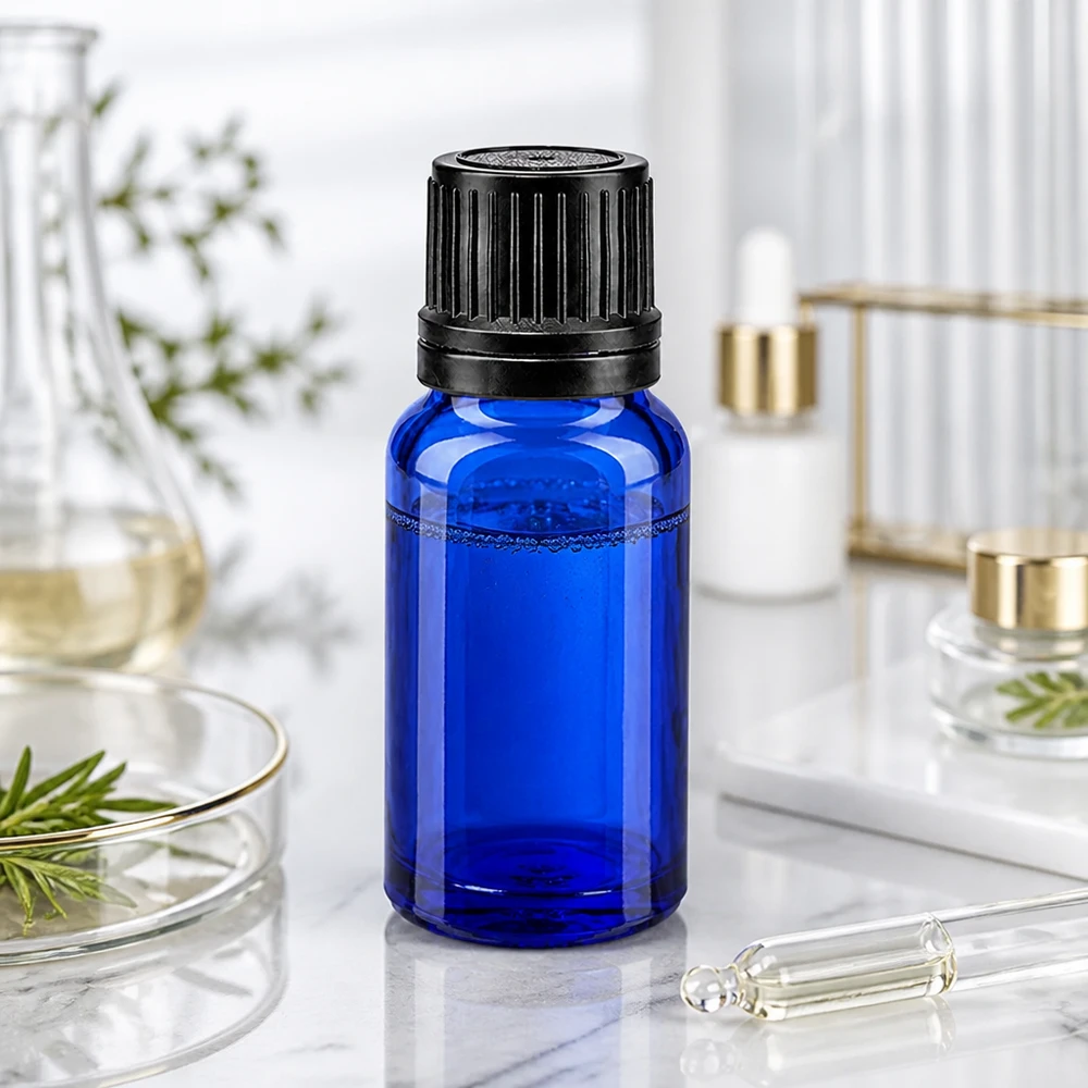 Frasco conta-gotas azul de 10 ml, em vidro com proteção UV, com tampa de segurança preta sobre fundo de mármore
