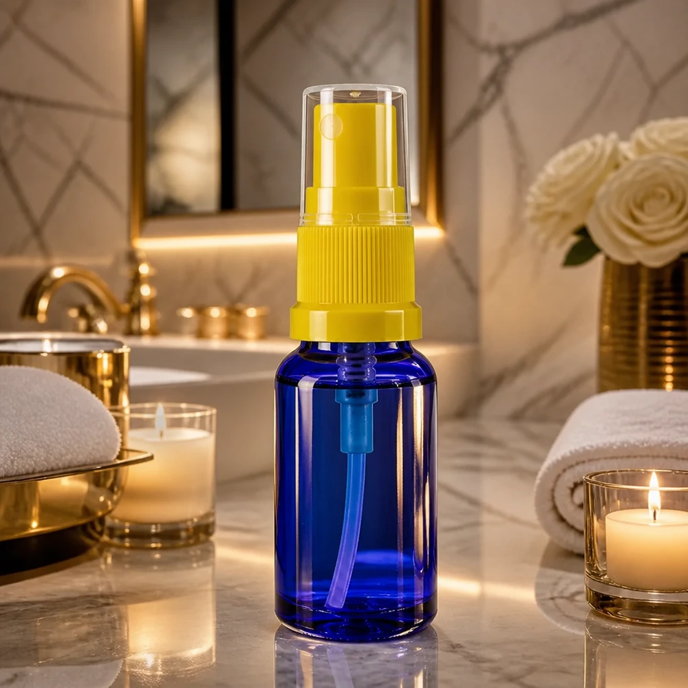 Pequeno frasco de vidro azul com pulverizador de 30 ml e bico amarelo sobre fundo de mármore