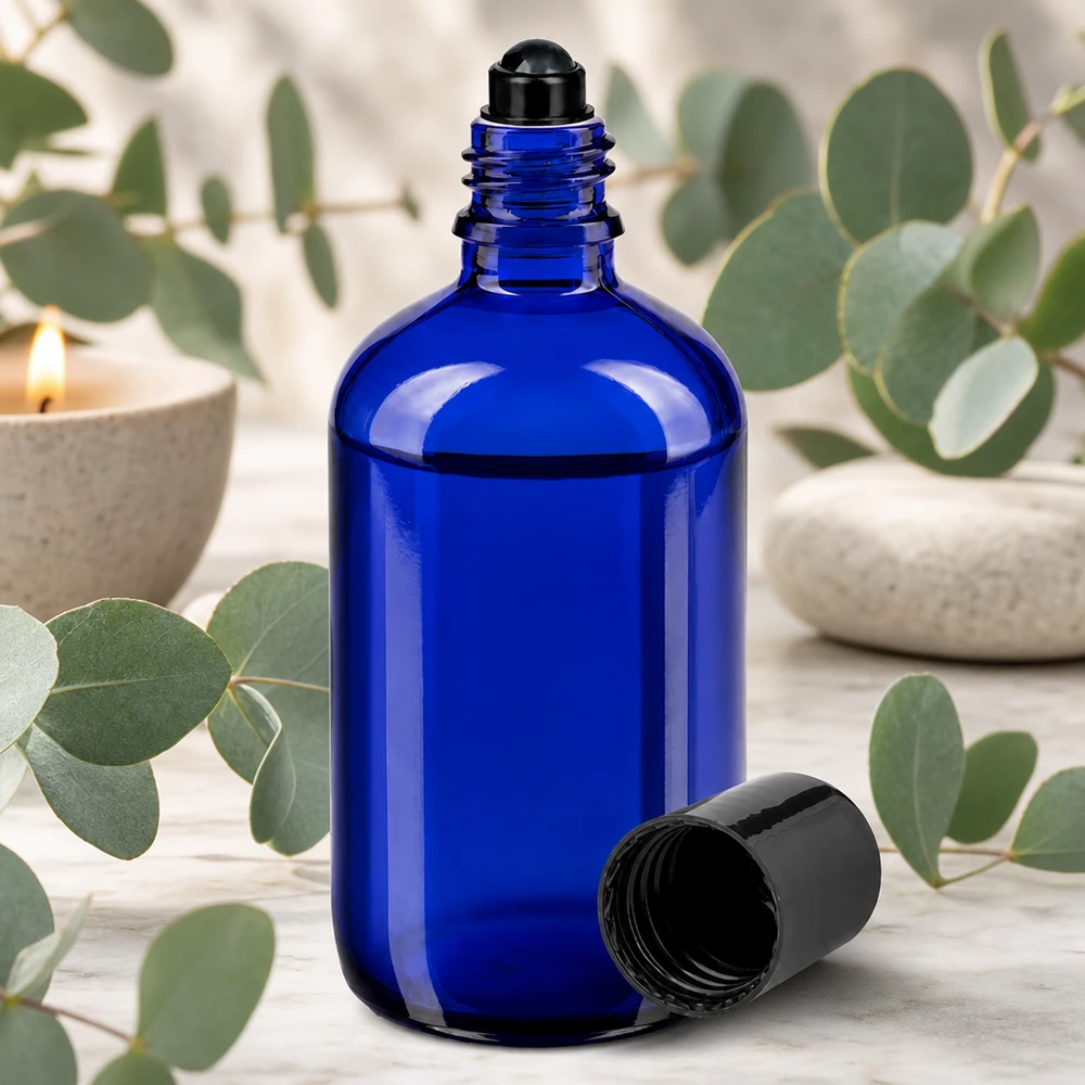 Frasco roll-on cilíndrico de 100 ml em azul cobalto com aplicador esférico preto e aroma a eucalipto