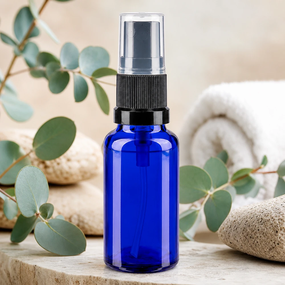 Frasco pulverizador compacto azul de 20 ml, em vidro com proteção UV, com bico pulverizador preto e tampa transparente