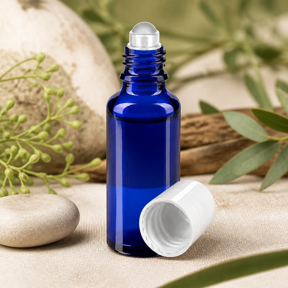 Frasco de vidro de farmácia azul de 30 ml com aplicador de aço inoxidável e tampa de rosca branca sobre pedra natural