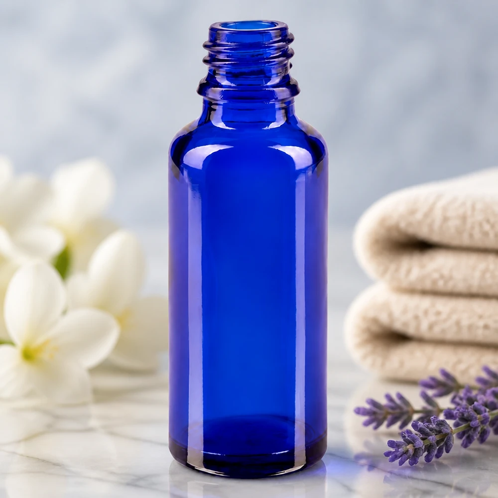 Frasco conta-gotas 30ml DIN 18 BLAUGLAS Frasco de farmácia ApoGlas vazio de 30 ml, em azul real, ao lado de um ramo de lavanda e flores brancas