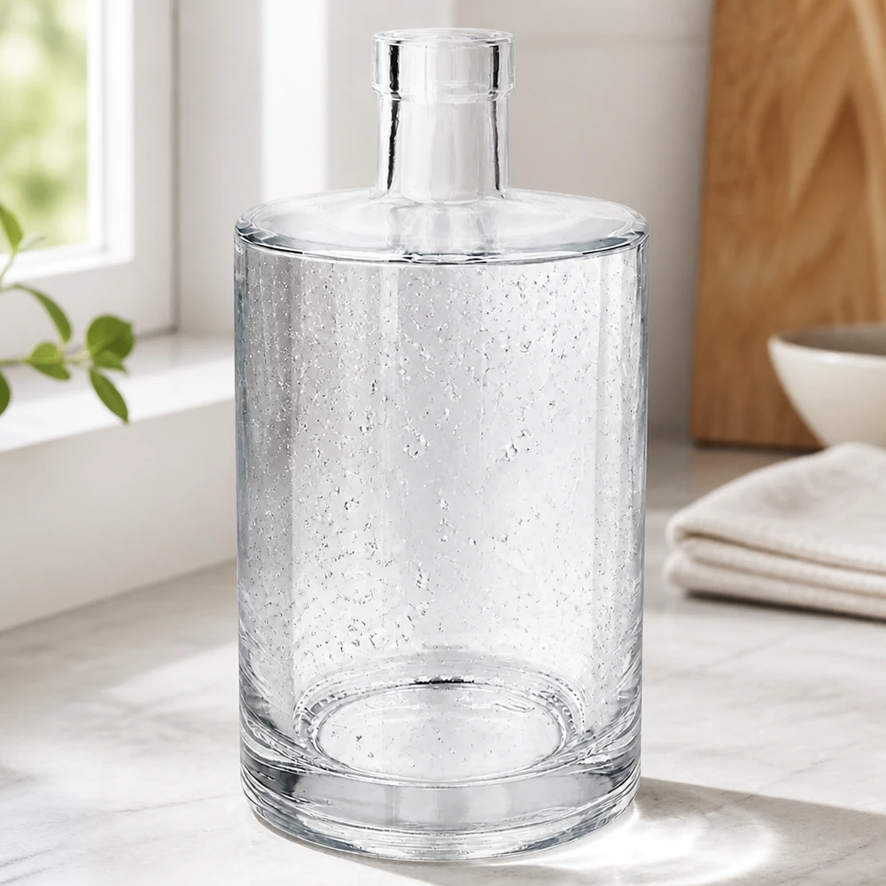 700ml Glasflasche "Galileo" ohne Verschluss UNiTWIST® Elegante 700ml Glasflasche Marie mit Luftbläschen-Optik in modernem Wohnambiente neben Handtüchern und Holzschale