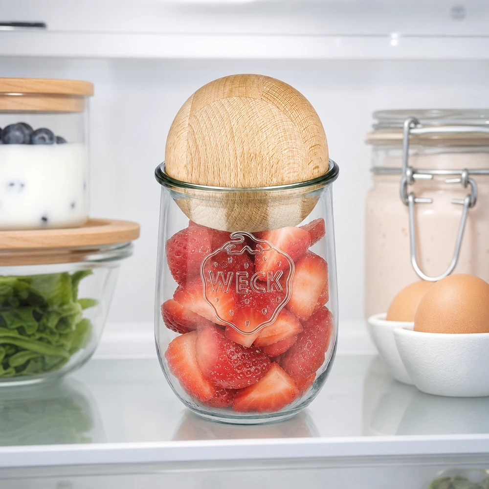 Frasco tulipa de 1062ml WECK RR100 com bola de madeira faia O frasco tulipa WECK de 1062 ml RR100 com bola de faia no frigorífico, cheio de morangos frescos, mostra uma retenção óptima da frescura