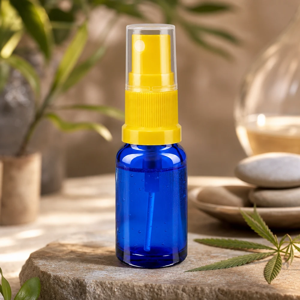 Mini-frasco conta-gotas azul de 10 ml com mecanismo de pulverização amarelo transparente sobre pedra natural com folha de canábis
