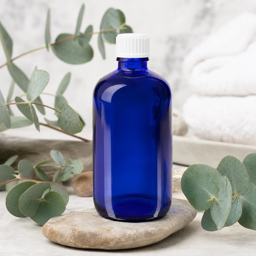 Frasco opaco de 100 ml, azul cobalto, com tampa conta-gotas branca de 0,9 mm, sobre pedra natural