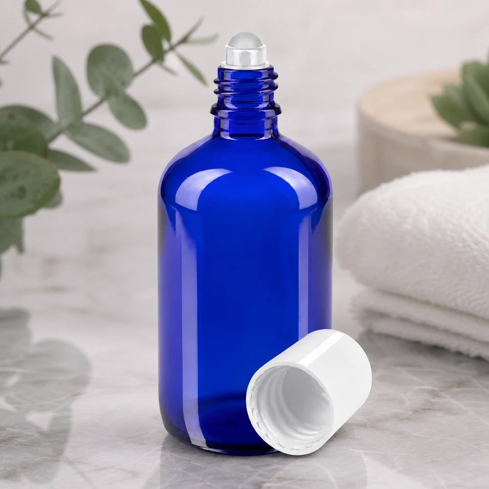 Frasco roll-on aberto de 100 ml em azul cobalto, com esfera de vidro transparente e tampa de plástico branca