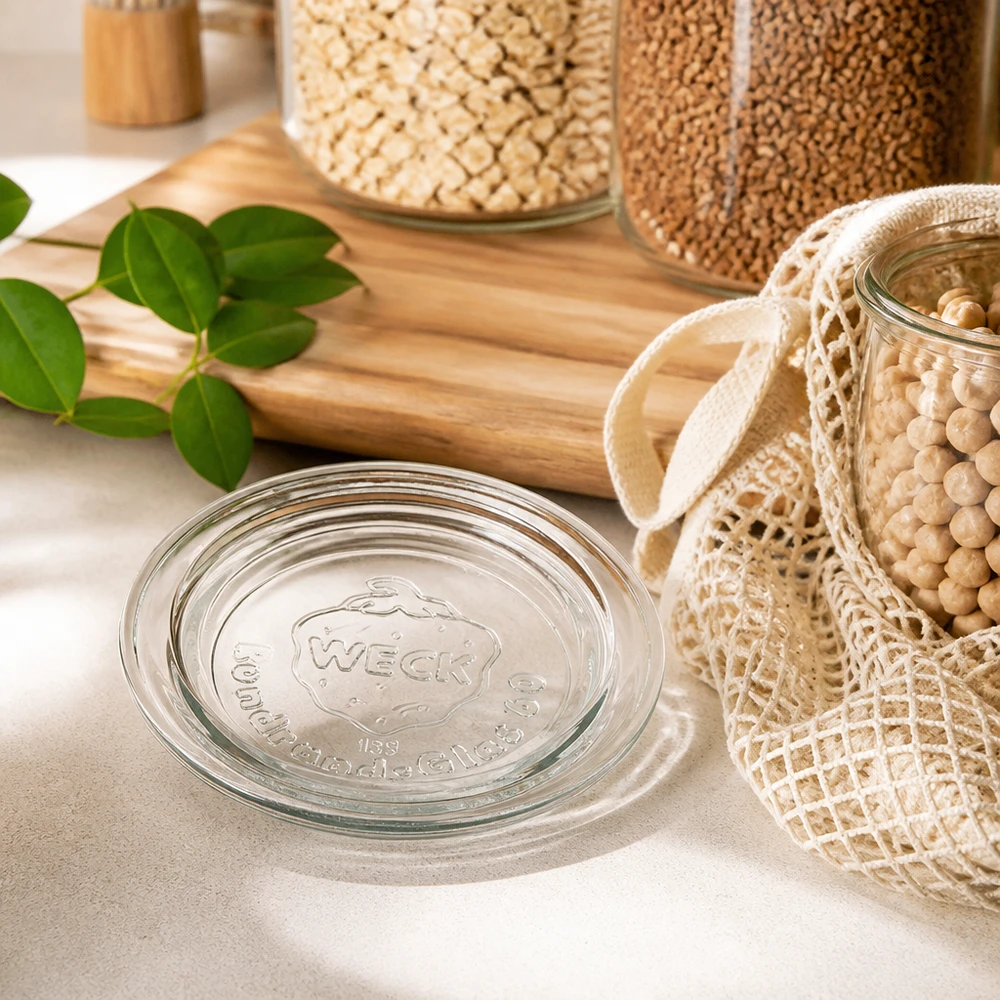 Tampa de vidro WECK RR60 em cozinha sustentável de desperdício zero com frascos de armazenamento de legumes e sacos de algodão