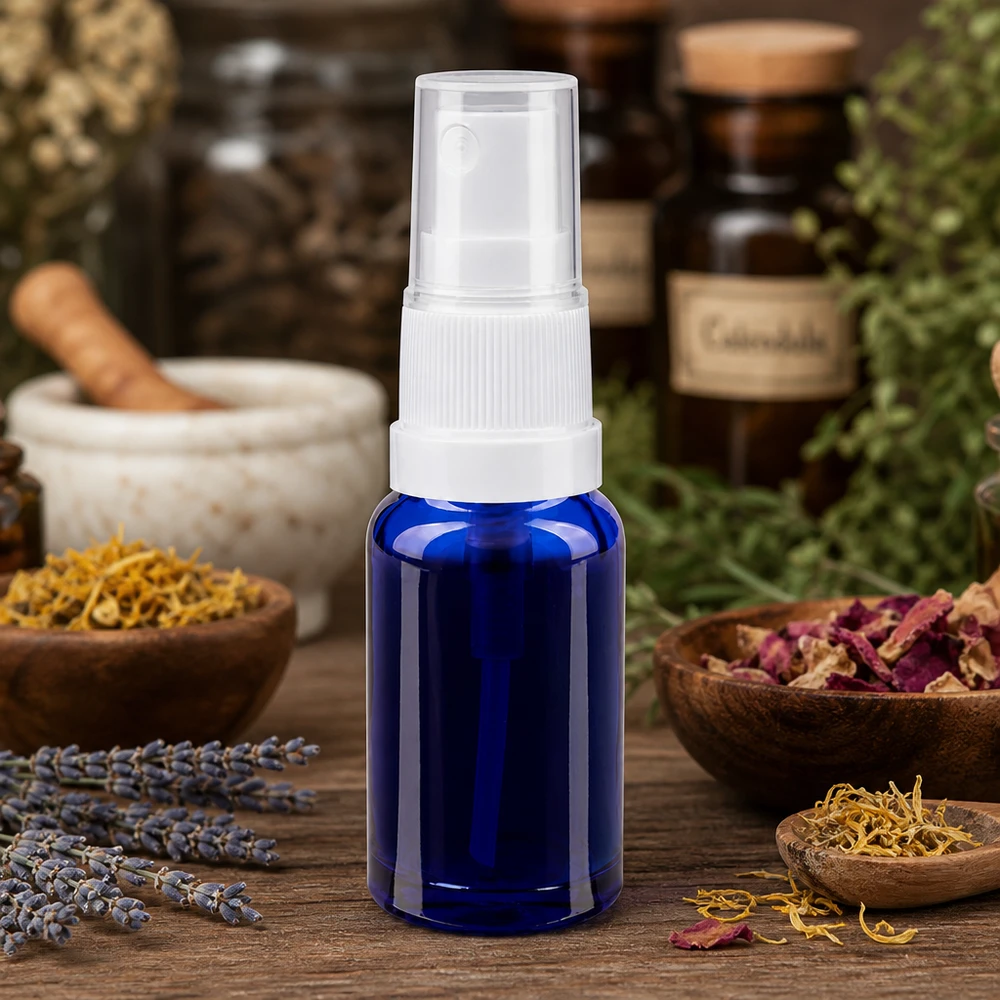 Frasco pulverizador de 10 ml em vidro azul de farmácia com pulverizador branco, rodeado por ervas medicinais e lavanda