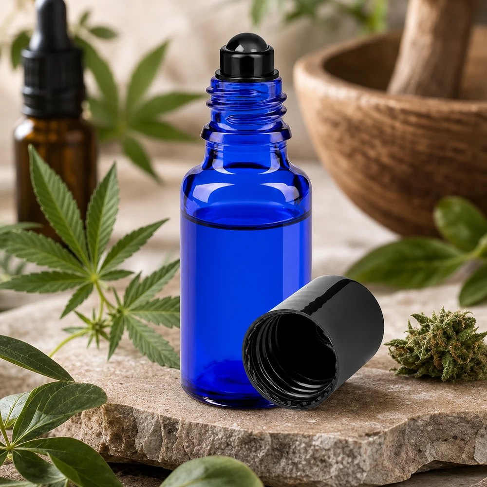 Pequeno frasco roll-on de 20 ml em vidro azul de farmácia ao lado de uma planta de canábis e de um almofariz