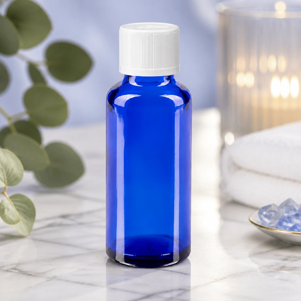 Frasco de farmácia azul 30ml tampa conta-gotas branco padrão resistente a crianças Frasco azul de farmácia de 30 ml com tampa de rosca branca, sobre mármore branco, ao lado de cristais e de uma vela