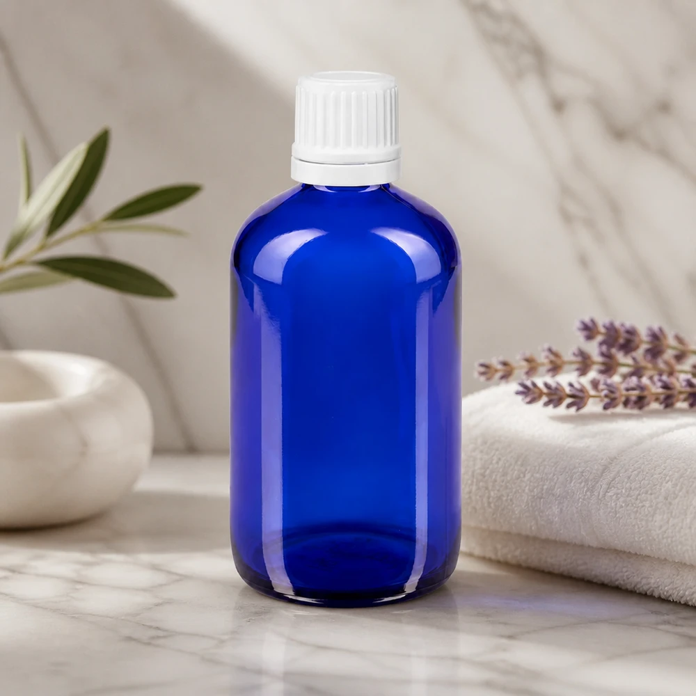 Frasco conta-gotas azul de 100 ml em vidro de farmácia com tampa OV branca sobre fundo de mármore