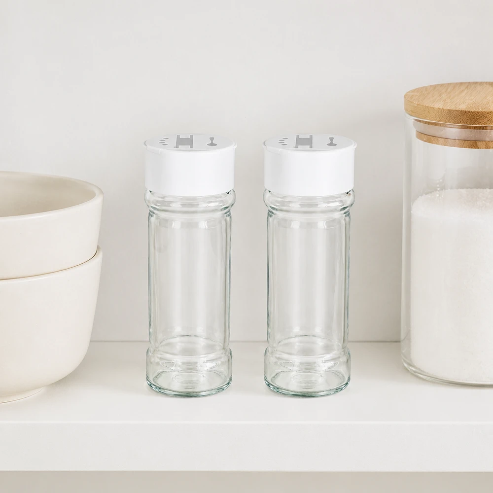 Frasco para sal/especiarias de 100 ml com espalhador duplo, branco Dois frascos de especiarias de 100 ml com tampa branca dupla para espalhar, lado a lado numa prateleira branca