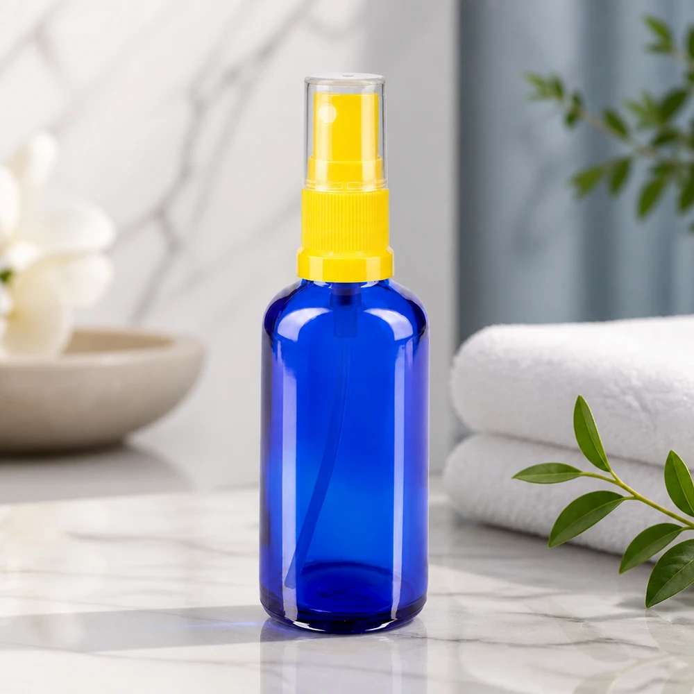 Frasco de farmácia azul 50ml spray top amarelo Frasco de vidro azul de farmácia de 50 ml com pulverizador amarelo sobre fundo de mármore