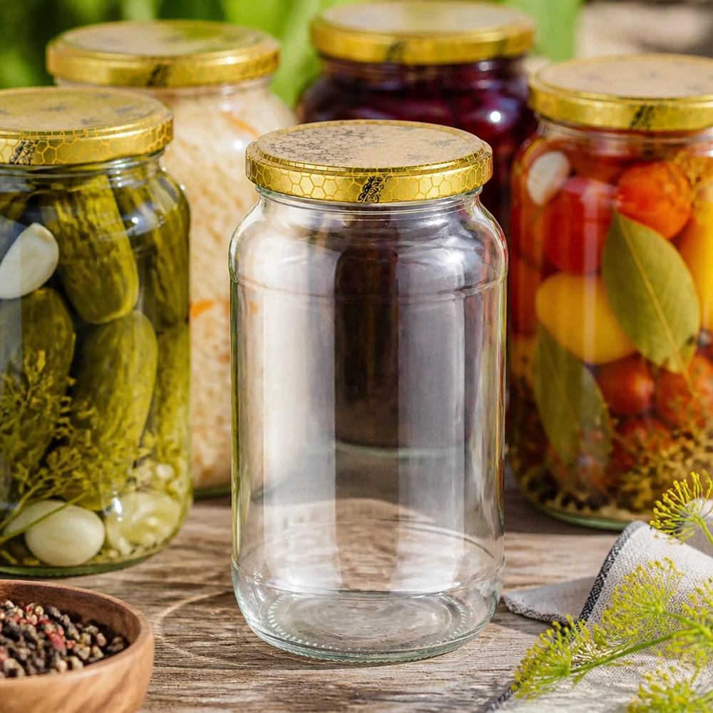 Frasco redondo de 1062 ml vazio entre frascos de conserva cheios com pepinos legumes tampa dourada em forma de favo de mel para conservar