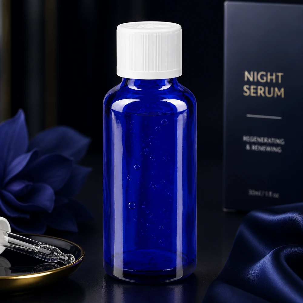 Elegante frasco de vidro cobalto de 30 ml para sérum noturno, com tampa KiSi branca sobre fundo escuro