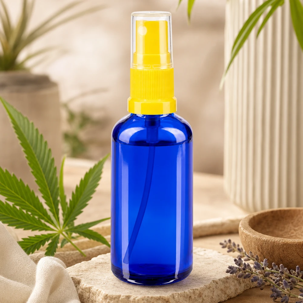 Frasco de farmácia azul 50ml spray top amarelo Frasco de spray STD azul de 50 ml, em vidro de farmácia, com pulverizador amarelo ao lado de uma folha de canábis
