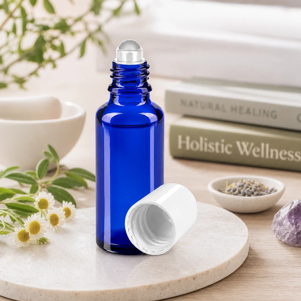 Frasco cilíndrico roll-on de 30 ml em azul cobalto com tampa branca, ao lado de ervas medicinais e de uma ametista