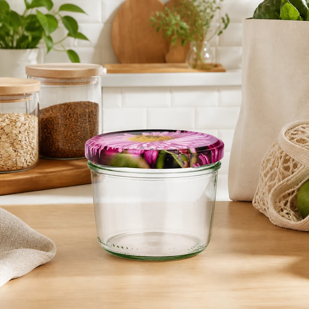 Copos de vidro de 230 ml + tampa BasicSeal design floral UNiTWIST Sturzglas 230ml leer mit rosa Blütendeckel in natürlicher Küchenumgebung, umgeben von Vorratsgläsern und Pflanzen