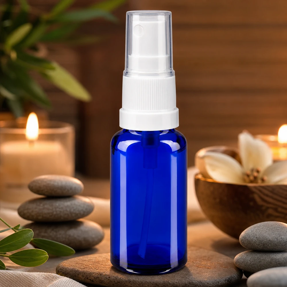 Frasco de farmácia azul 20ml spray acessório branco Frasco de vidro de farmácia azul de 20 ml com pulverizador branco, num ambiente de spa de bem-estar com velas