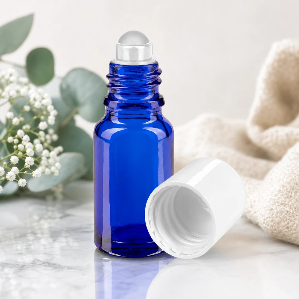 Frasco de farmácia azul 10ml tampa roll-on branca Frasco roll-on de vidro de farmácia azul cobalto, de 10 ml, com esfera de vidro transparente sobre fundo de mármore