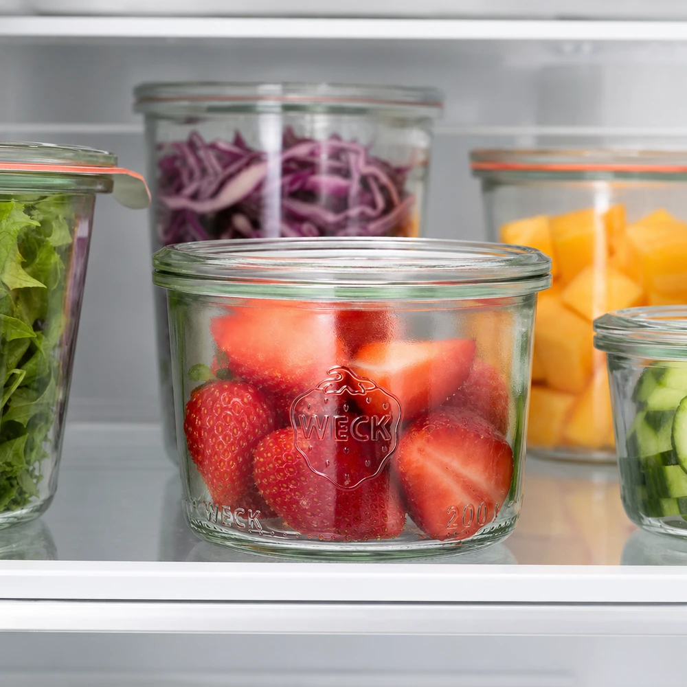 Frasco de vidro de 200 ml WECK RR80 Copos WECK RR80 de 200 ml com morangos frescos no frigorífico, juntamente com outros frascos cheios de fruta e legumes