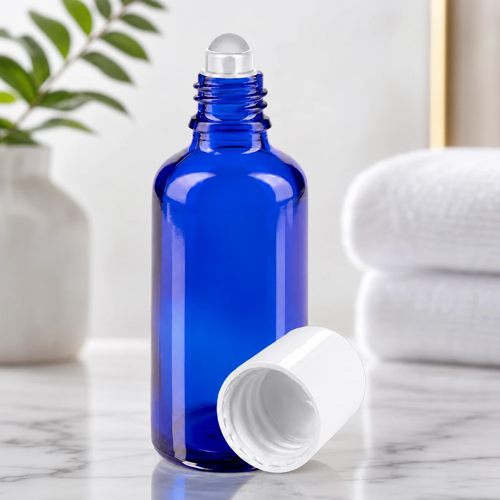 Frasco de vidro de farmácia cilíndrico de 50 ml, na cor azul, com esferinha deslizante e tampa branca aberta
