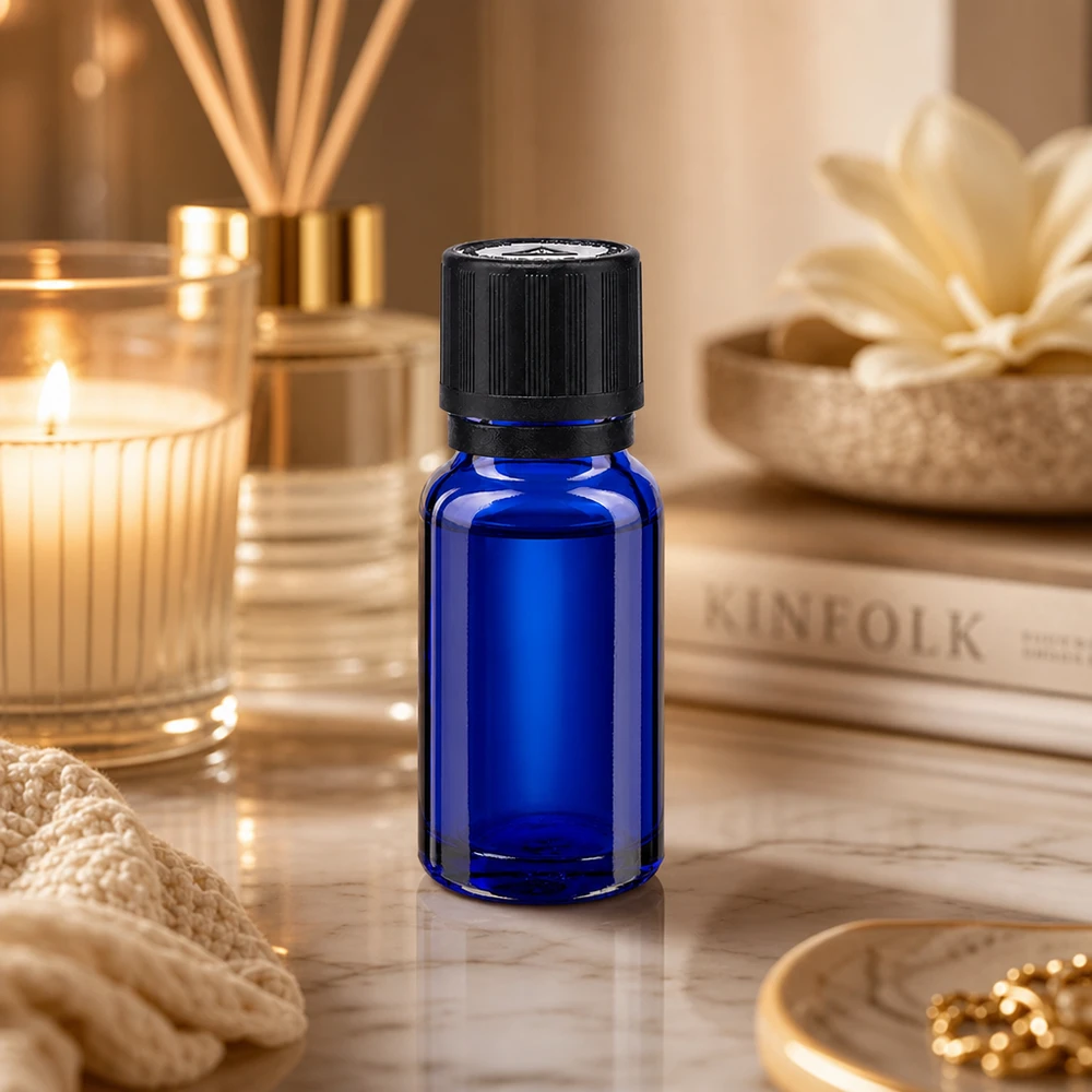 Pequeno frasco de vidro azul de 10 ml com tampa de segurança infantil preta sobre um elegante fundo de mármore