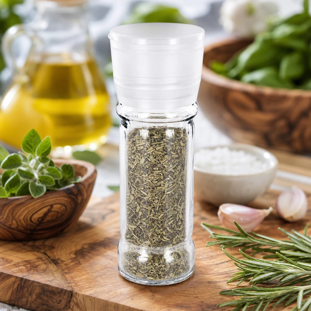 Frasco para especiarias de 100 ml com moinho branco, cheio de ervas aromáticas, ao lado de alecrim e alho