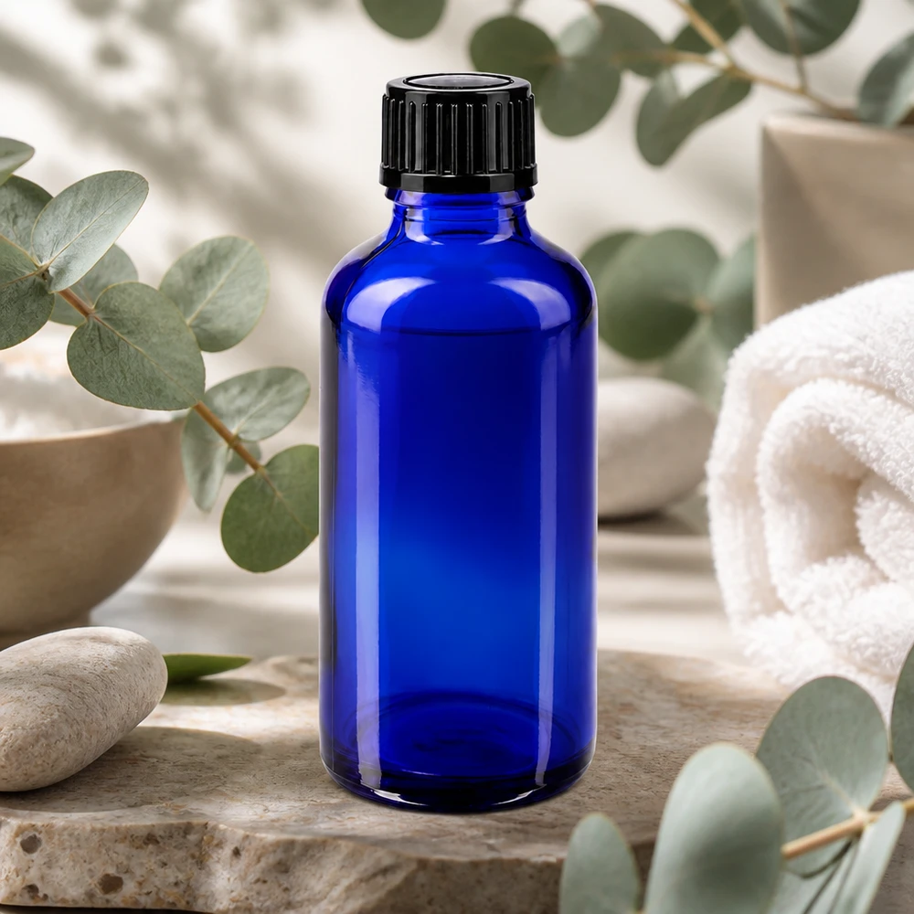 Frasco de farmácia azul de vidro de 50 ml com tampa de rosca preta, sobre pedra natural com aroma a eucalipto