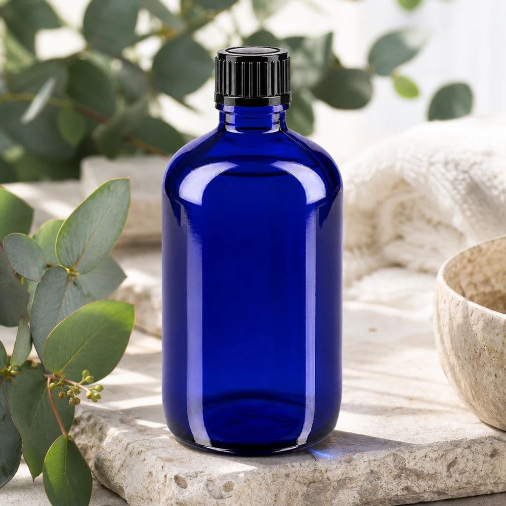 Frasco de farmácia azul de 100 ml com tampa preta padrão sobre pedra natural com aroma a eucalipto