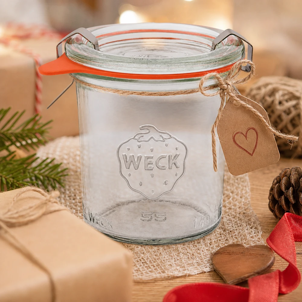 Copos WECK RR60 de 140 ml como ideia de presente, decorados com um pendente de coração e um cordão de juta numa mesa de madeira com pinhas