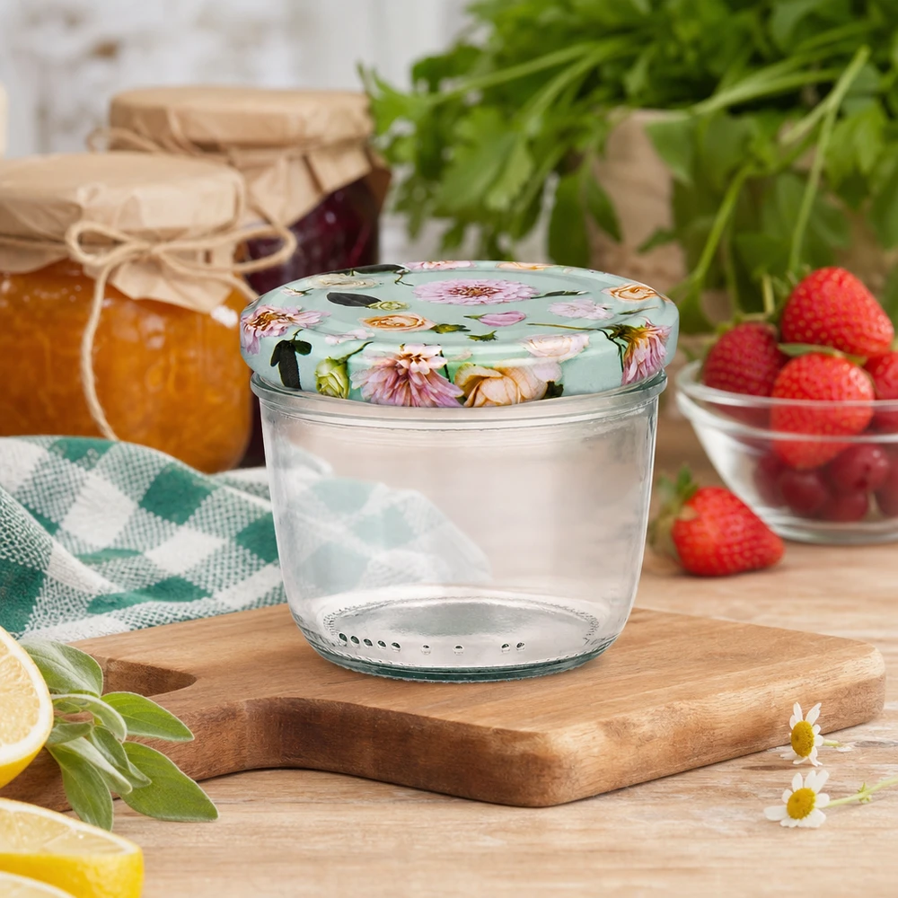 Copos de vidro de 230 ml + tampa BasicSeal flor de menta UNiTWIST Copos de 230 ml com tampa floral BasicSeal em tábua de madeira, cenário de cozinha com compota, morangos e ervas aromáticas